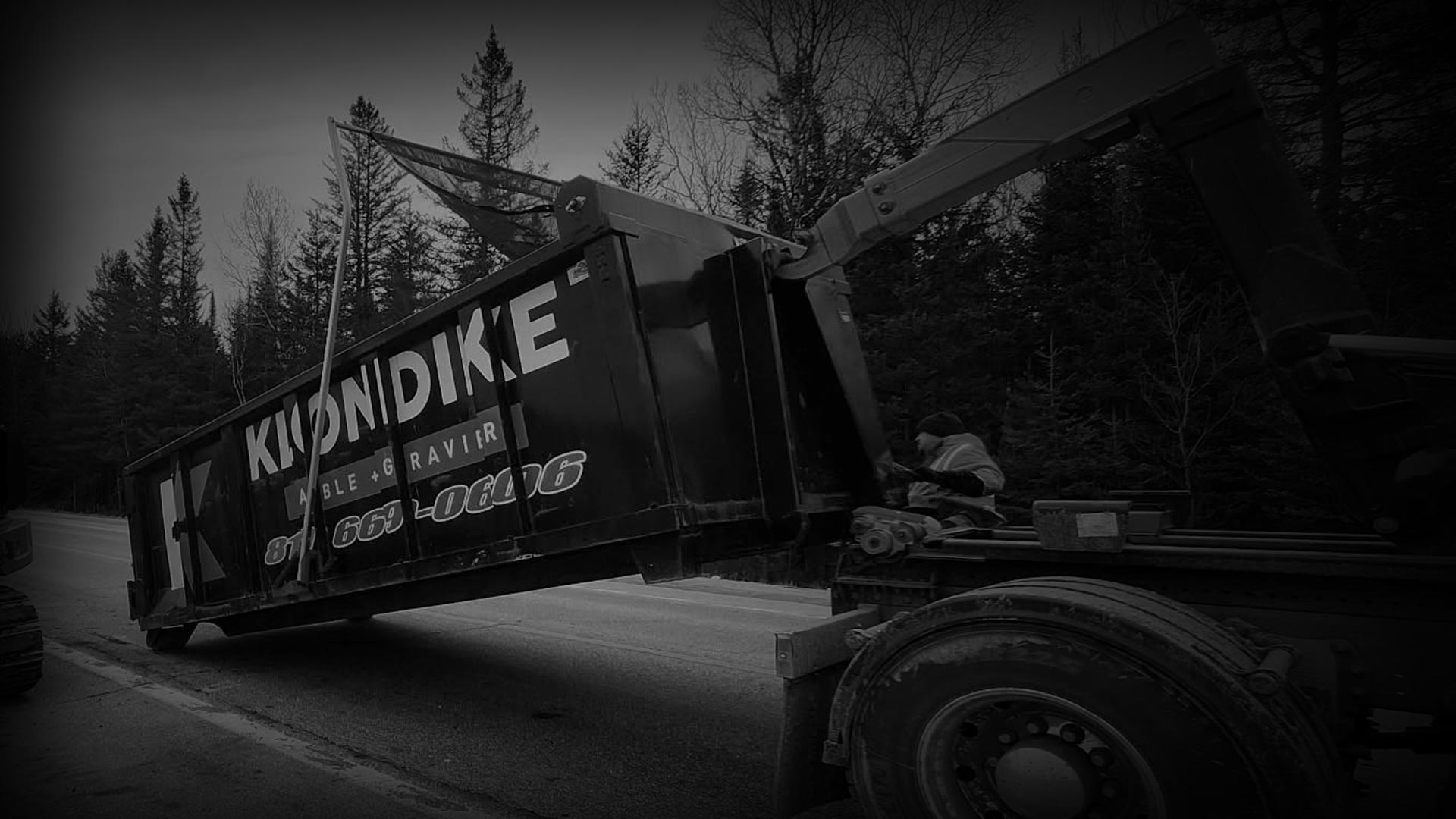 Expert de Klondike environnemental en action à effectuer un pompage d'eau usé sur la route avec camion et équipements